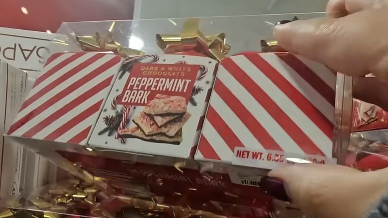hand holding a red and white striped package of peppermint bark
