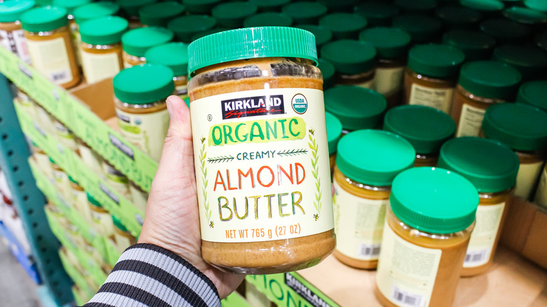 Man holding a tube of creamy almond butter