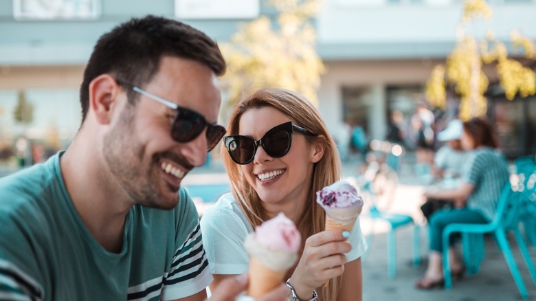 Couple wearing sunglasses, eating ice cream