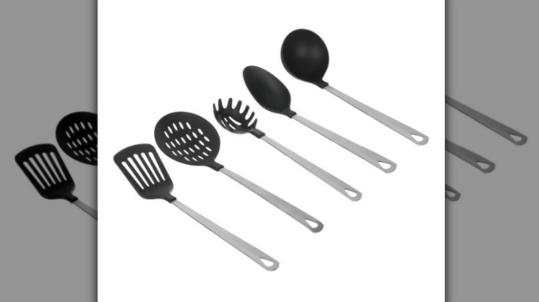 Cooking utensil set with metal handles and black plastic tops on white background