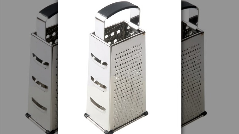 A metal box grater on a white background