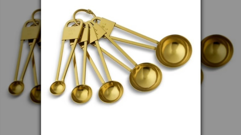 Stainless steel gold measuring spoon set on white background