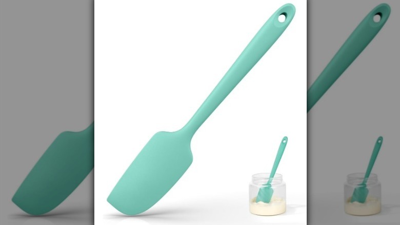 A light teal silicone spatula on white background