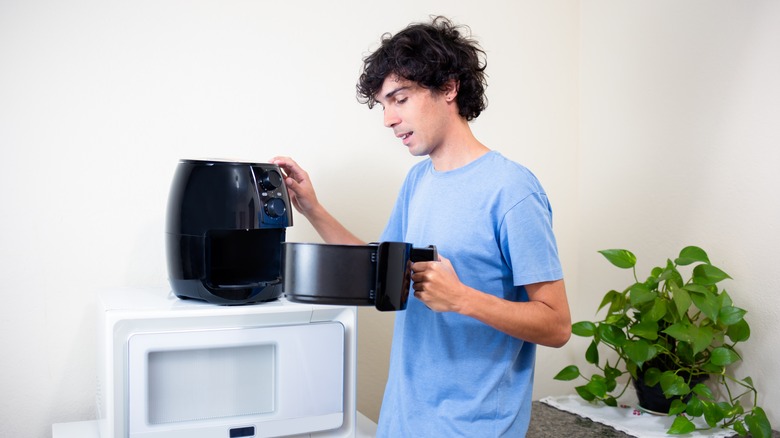 Man checking air fryer basket