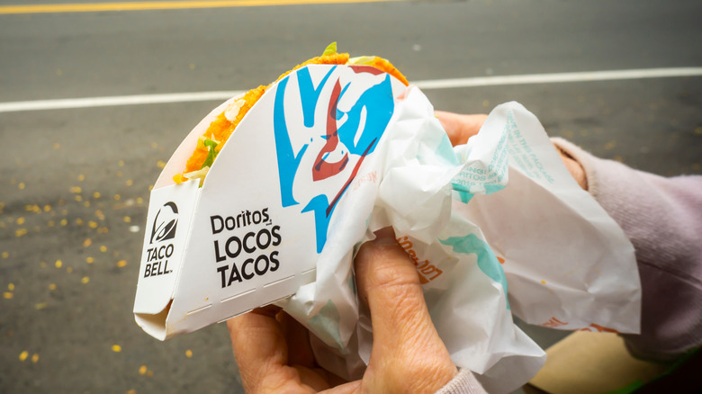 Person holding Doritos Taco Bell taco