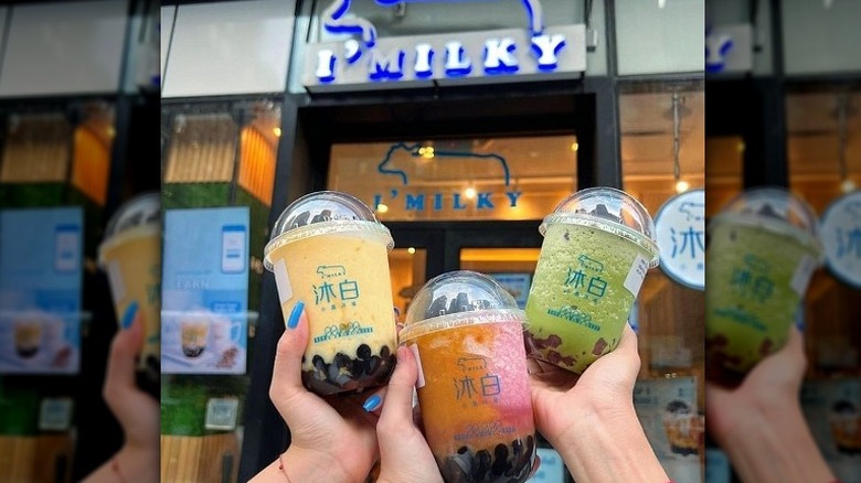 Hands holding I'Milky drinks
