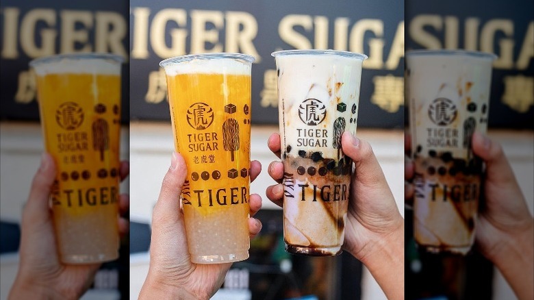 Hands holding Tiger Sugar drinks