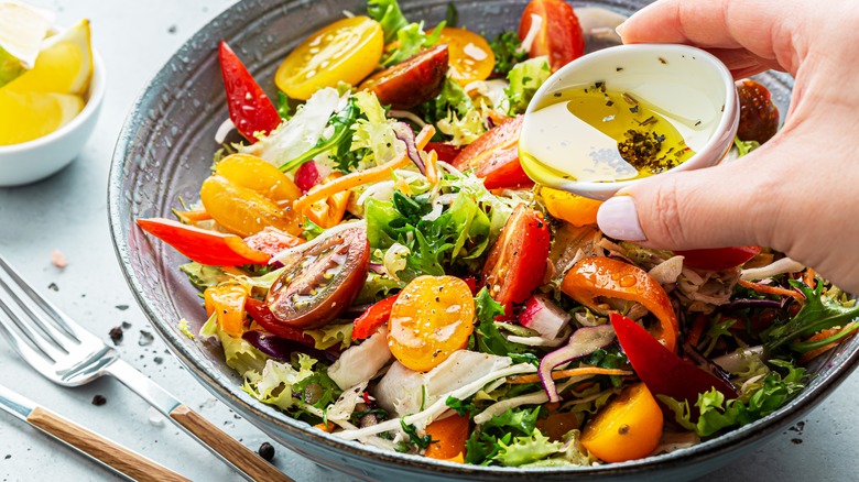 Dressing poured over colorful salad