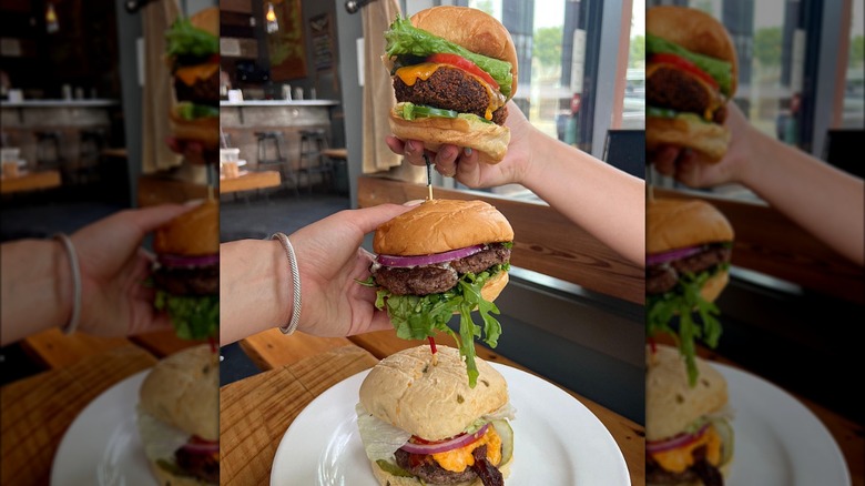 Hands holding burgers