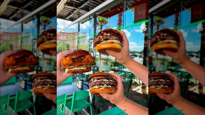 Hands holding burgers