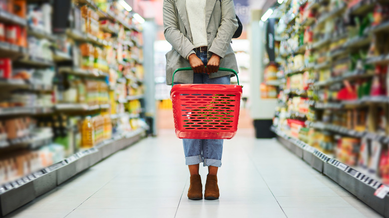 Woman holding red shopping basket