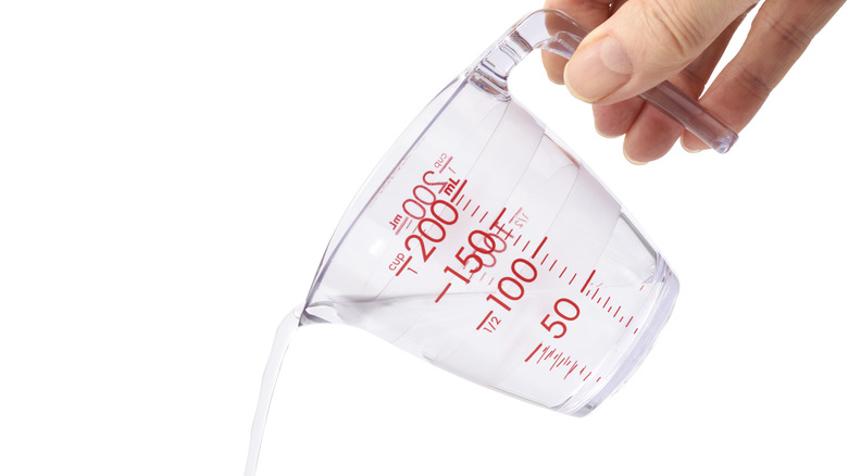 Person pouring water from cup