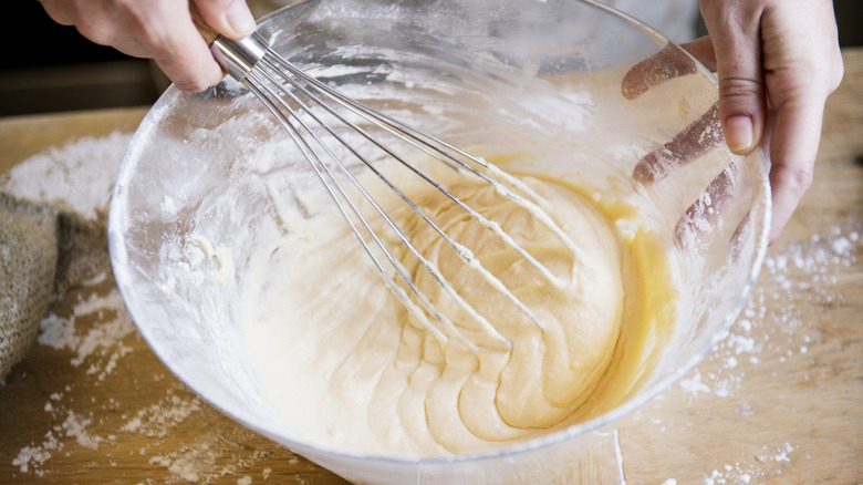 whisking cake mix in a glass bowl