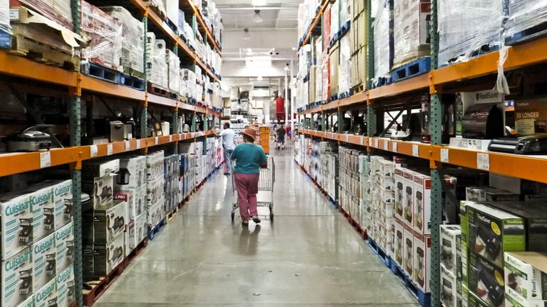 A shopper walks down an aisle at Costco