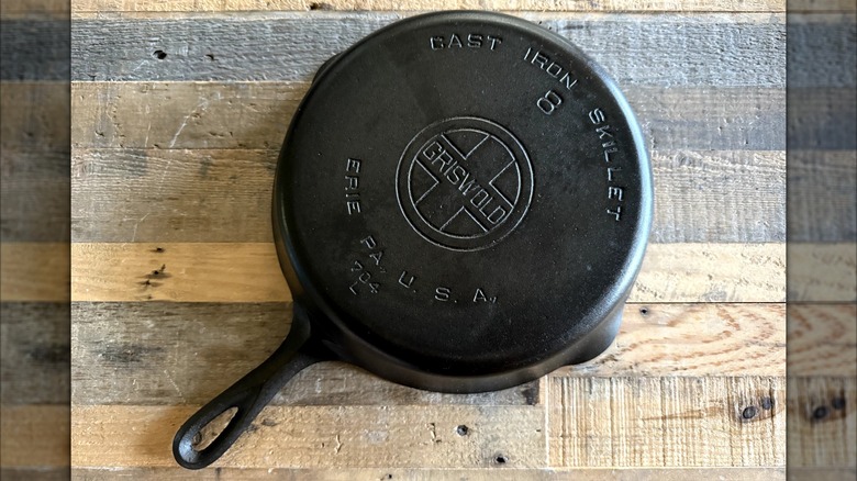 A #8 Griswold cast iron skillet on a wooden table, flipped over to show the bottom pan markings