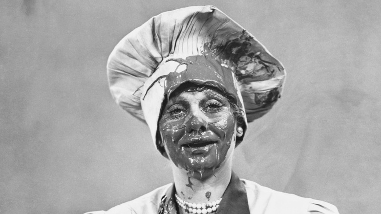 Lucille Ball looking wearing chef's hat, covered in chocolate