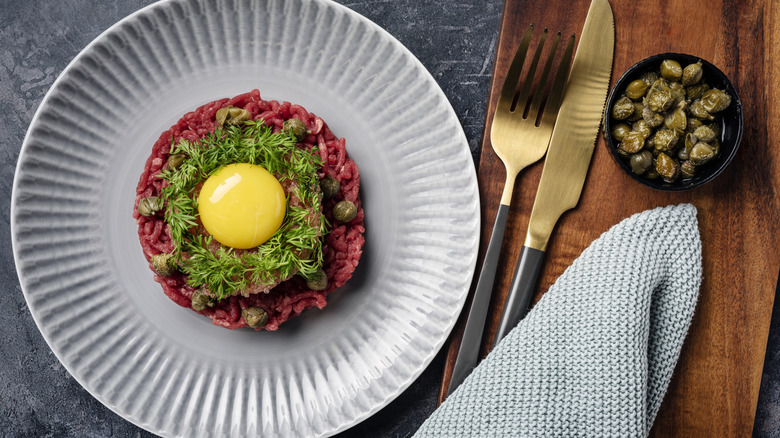 Overhead view of steak tartare that is topped with a raw egg