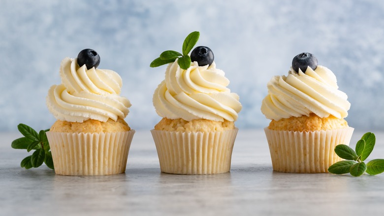 Three vanilla cupcakes with blueberries