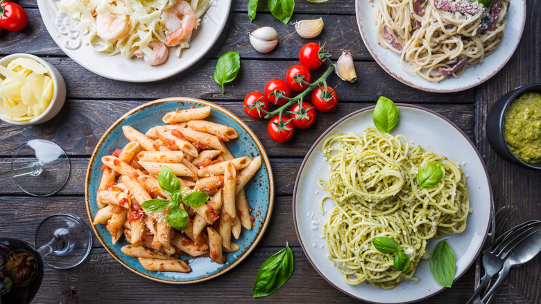 Different types of plated pasta dishes on a table
