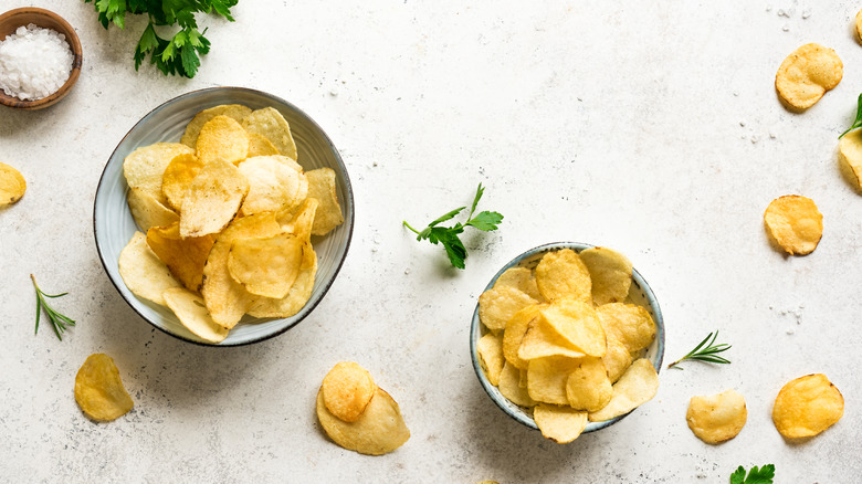 Potato chips in bowls with herbs 