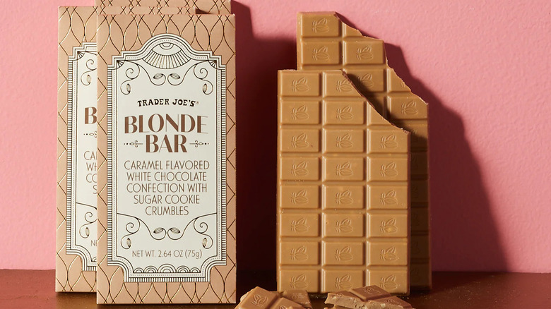 Opened Blonde Bar and the beige and cream package against pink wall