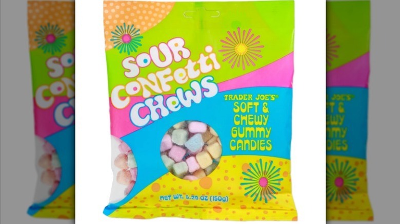 Sour confetti chews in an orange, lime green, pink, baby blue, and yellow bag on white background
