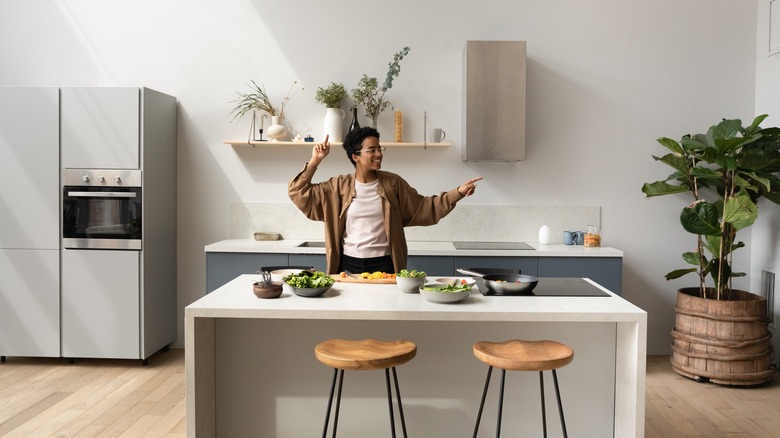 A person dances in their kitchen