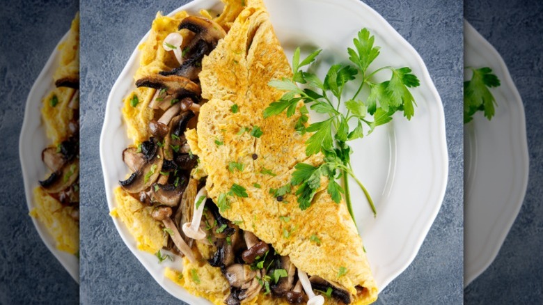 An omelet stuffed with mushrooms and garnished with herbs