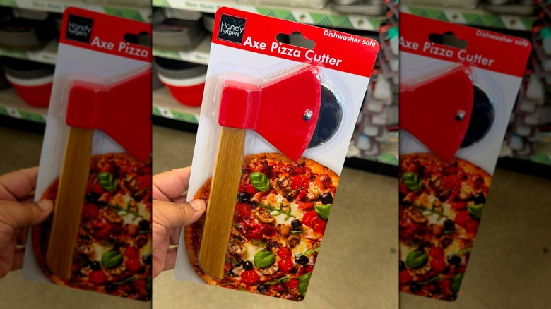 A hand holding a Handy Helpers Axe Pizza Cutter in-store