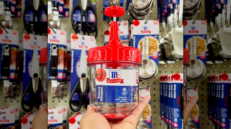A hand holding a McCormick Food Chopper in-store