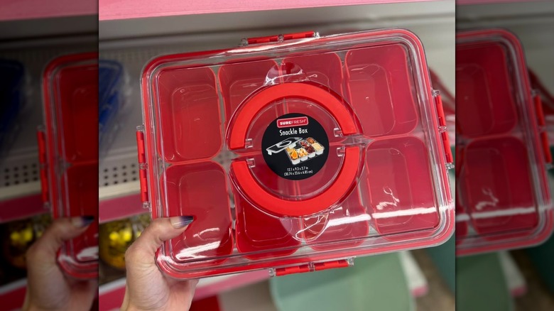 A hand holding a red SureFresh Snackle Box in-store