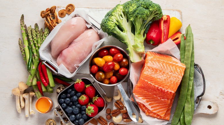 Various organic food items, including vegetables, chicken breasts, and salmon