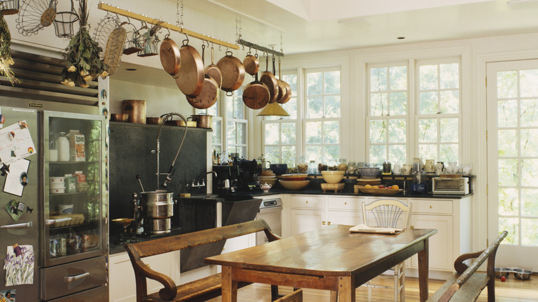 Kitchen with hanging pots and pans and dining table