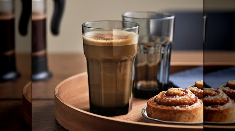 Coffee in a glass cup with a pastry on a tray