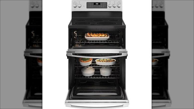 Open view of the GE 30-inch glass-top 5-burner freestanding double oven electric range against a white background.