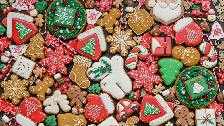 assorted christmas sugar cookies with stockings, candy canes, snowflakes, gingerbread men, and more in a red, brown, green, and white color palette.