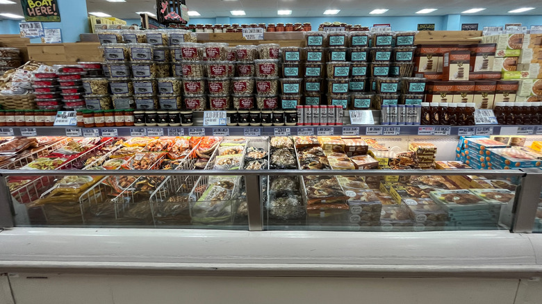 frozen food aisle at Trader Joe's with items stocked on the shelves and the cold case below.
