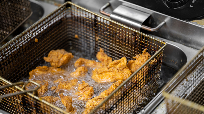 Fried chicken lifted from a commercial fryer.