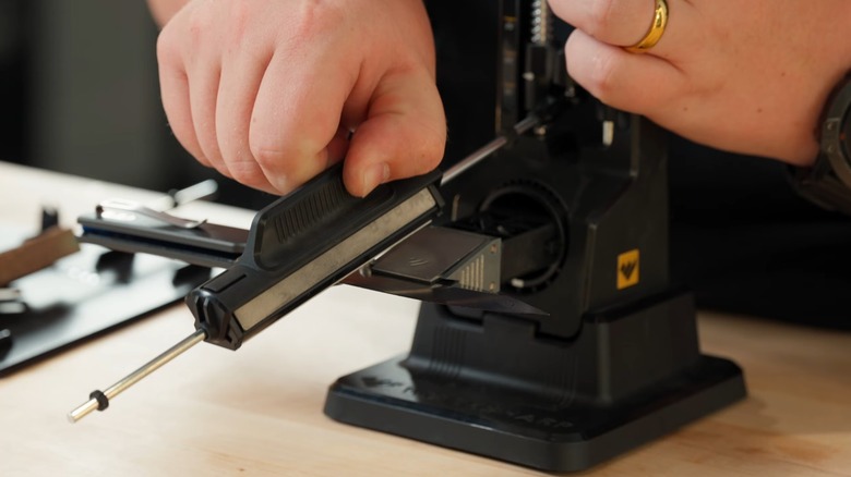 Person using a fixed angle sharpener on a utility knife