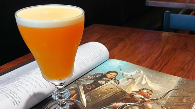 A cocktail sitting on a Dungeons & Dragons player handbook