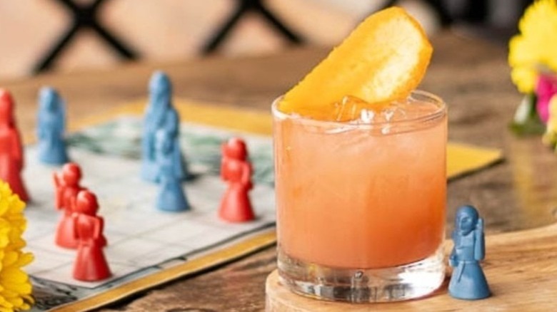 Cocktail next to a gaming board at Mox Boarding House