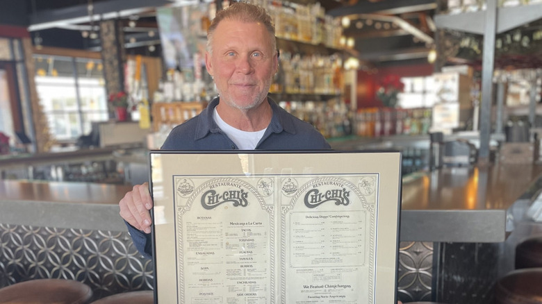 Michael McDermott holding framed Chi-Chi's menu