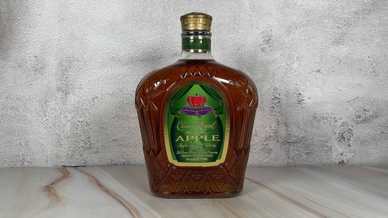 Bottle of Crown Royal apple whiskey on grey background