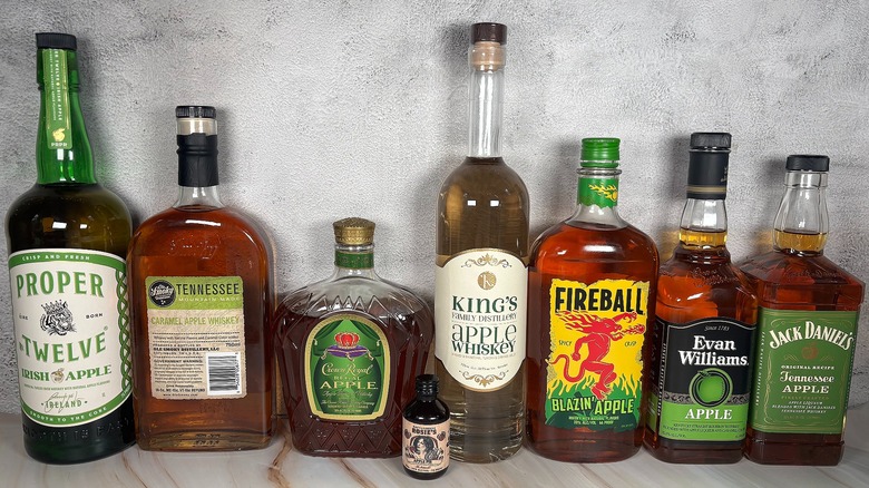 Nine bottles of apple whiskey lined up on table
