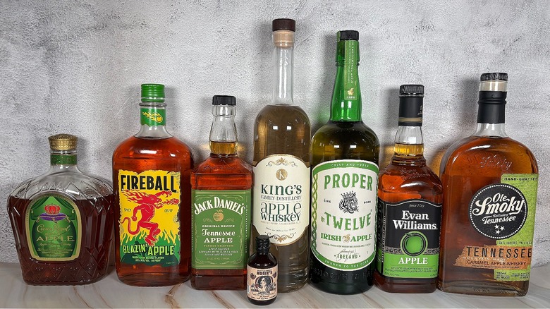 Nine bottles of apple whiskey lined up on table