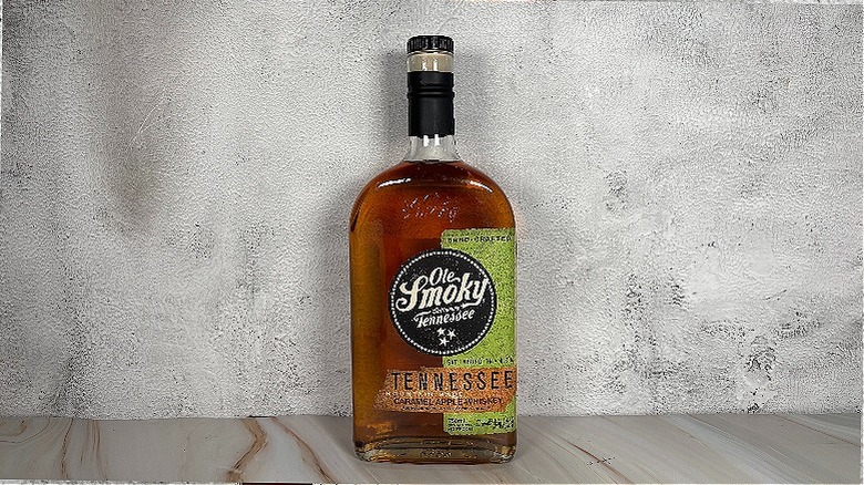 Bottle of Ole Smoky apple whiskey on grey background