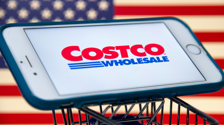 Costco logo on a phone in front of an American flag
