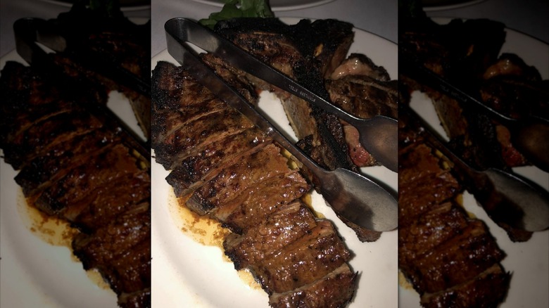 a plated porterhouse steak with a leafy garnish