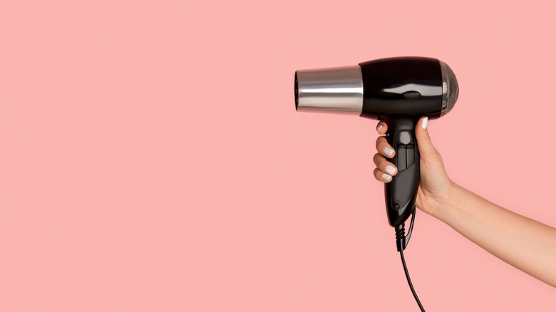Person holding blow dryer