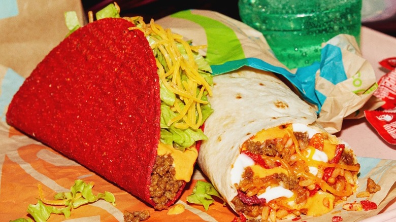 Taco with a bright red shell next to Taco Bell burrito with rice, cheese, and meat
